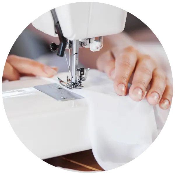 maszyna do szycia i osoba wykonująca drobne poprawki krawieckie